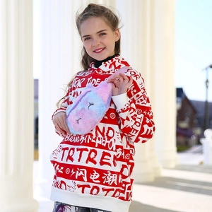 Close-up of a child wearing a colorful gradient plush unicorn fanny pack and hoodie