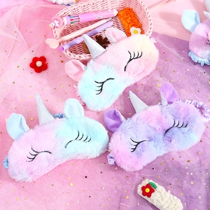 Detail of plush unicorn sleep masks in macaron gradient colors with silver horns
