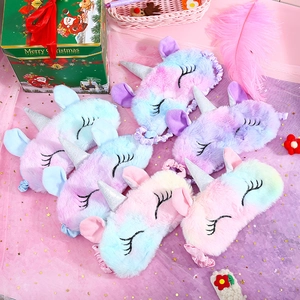 Multiple colorful plush unicorn sleep masks with rainbow gradient and silver glitter horn