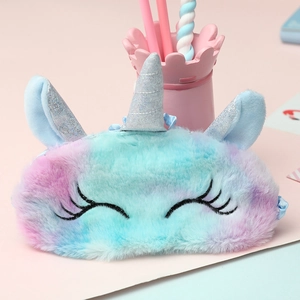Close-up of a fluffy unicorn sleep mask with colorful tie-dye fur and silver horn detail
