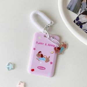 Pink cartoon puppy card holder with retractable spring lanyard and acrylic charm on table