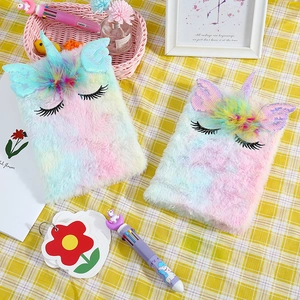 Close-up of plush unicorn notebooks with rainbow fur, sequin wings and 3D details