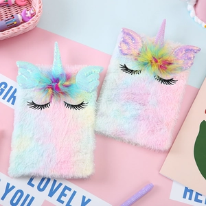 Detailed view of rainbow plush unicorn notebooks with sequin horns and feather details