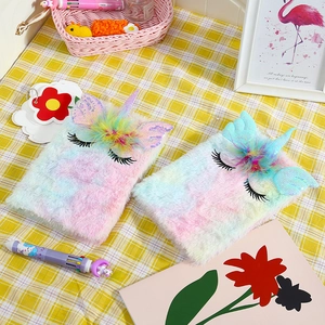 Close-up of rainbow plush unicorn notebook with 3D horn and sequined wings