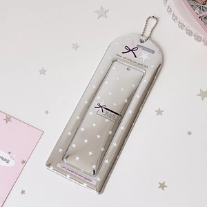 Detail of silver metallic photo card holder with stars and bead chain on white surface