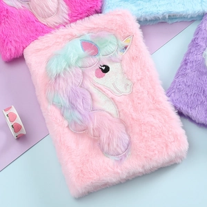 Close-up of pink plush unicorn notebook with colorful faux fur and detailed embroidery