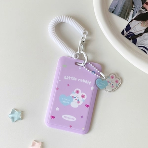 Detail of purple cartoon card holder with white spiral lanyard and rabbit charm