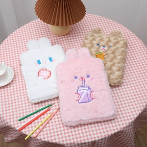 Three plush cartoon iPad sleeves in white, pink, and brown on a checkered tablecloth