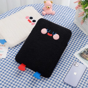 Macro shot of fluffy teddy fleece tablet cases with cute embroidered cartoon faces