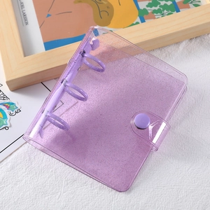Close-up of a mini 3-ring binder made of purple glitter PVC with a metal clasp