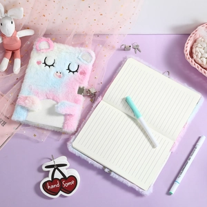 Detail of plush cat diary featuring gradient fur, embroidered face and metal heart lock
