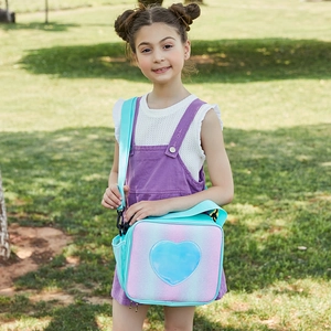 Girl carrying pink and purple glitter lunch bag with blue heart and adjustable strap