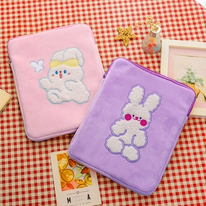 Close-up of pink and purple plush tablet sleeves with cute embroidered rabbit patterns