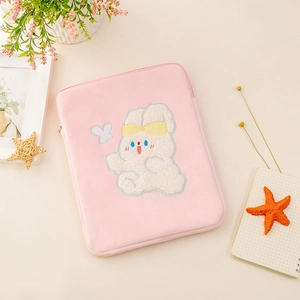 Detail of pink plush iPad sleeve featuring cute cartoon embroidery and soft zip closure