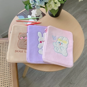 Close-up of soft plush tablet sleeves in beige and pink with cute animal embroidery
