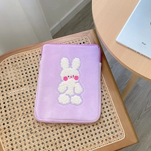 Close-up of purple plush tablet sleeve featuring cute 3D bunny embroidery and soft texture
