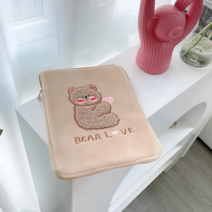Close-up of cute beige plush tablet sleeve with cartoon bear embroidery and metal zipper