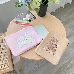 Detailed view of plush laptop sleeves with cute rabbit and bear embroidery designs