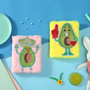 Details der flauschigen Avocado-Notizbücher mit glitzernder Stickerei und weichem Kunstfell