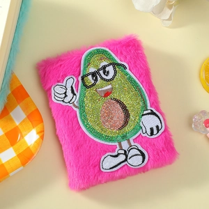 Details des rosa Plüsch-Notizbuchs mit besticktem Avocado-Motiv aus glänzenden Pailletten