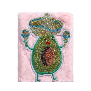 Detailansicht eines rosa Plüsch-Notizbuchs mit einem Pailletten-Avocado-Motiv