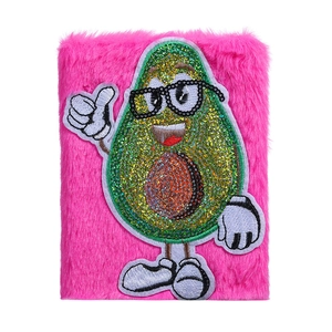 Detailansicht eines rosa Plüsch-Notizbuchs mit süßer Avocado-Stickerei und Pailletten