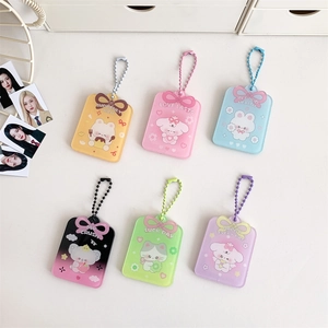 Detailed flat lay of six colorful acrylic bow ID card holders with bead chains on a white desk