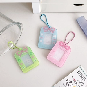 Close-up of pastel bow acrylic card holders with bead chains and cute cartoon patterns