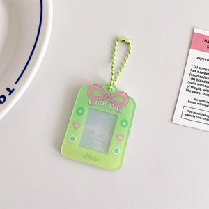 Detail of light green acrylic photo card holder with pink bow and bead chain