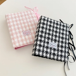 Detail of A5 tweed plaid photo album covers with ribbon ties and woven logo label
