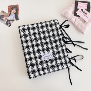 Detail of A5 houndstooth fabric binder with black ribbon bow and metal ring binder clip