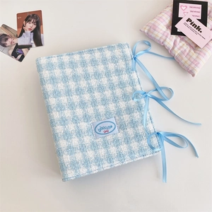 Close-up of blue plaid tweed A5 binder with decorative ribbons and fabric logo