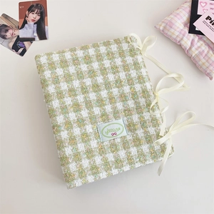 Detail of A5 green tweed photocard binder with ribbon bows and isocute woven label