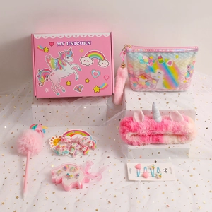 Detailed view of unicorn plush notebook gift set with pink sequin bag and hair accessories