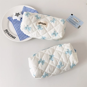 Detailed close-up of quilted pencil cases with blue bow prints and secure zipper