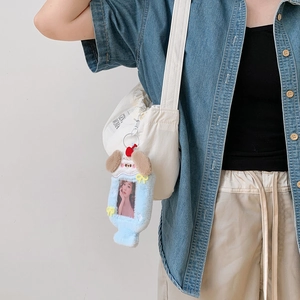 Gros plan du mignon porte-carte en peluche chien bleu clair avec décor cerise sur un sac