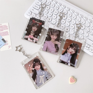 Transparent acrylic photocard holders with star-shaped clasps on a white keyboard