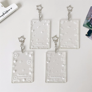 Detail of four transparent acrylic photocard holders with star-shaped metal keychains
