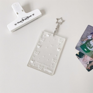 Detail of clear acrylic photo card holder with white butterfly prints and star keychain