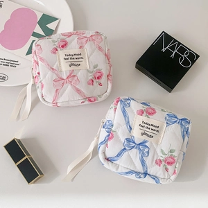Detailopname van gewatteerde katoenen tasjes met bloemenstrikpatroon en satijnen lintjes