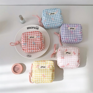 Flat lay of macaron-colored checkered pouches with bow patterns and zipper closures