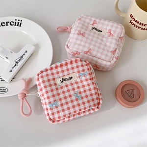 Detailed view of square checkered canvas pouches with bow patterns and cotton cord puller