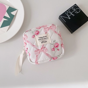 Detail van gewatteerd bloementasje met roze lint en vintage rozenpatroon