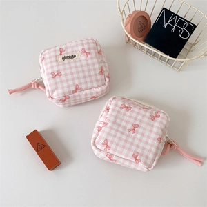 Macro detail of pink checkered makeup bags with red bow patterns and zip pulls