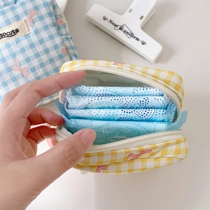 Checkered fabric cosmetic pouch with pink bow and white zipper for daily essentials