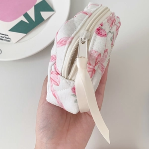 Detail van gewatteerde kleine opbergtas met roze tulp patroon en lint aan de rits