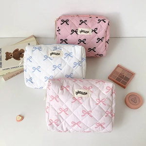 Minimalist quilted cotton cosmetic bag with bow print and secure zipper closure