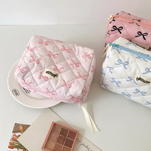 Quilted cotton cosmetic bags with ribbon zippers and cute bow patterns in three colors