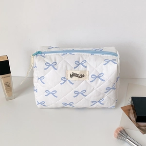 Close-up of quilted cosmetic bag with blue ribbon prints and Hisocute brand label