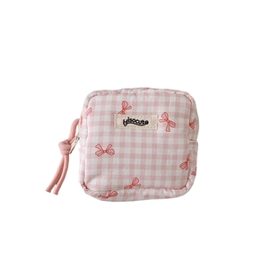 Pink and white checkered square makeup bag with a red bow and a pink zipper closure